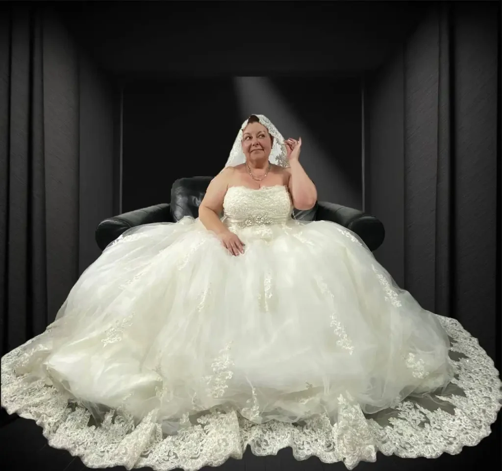 A woman in a white wedding dress sitting on a couch with a veil